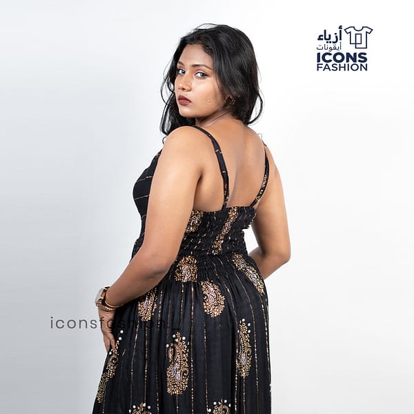 Black-sleeveless-maxi-dress-with-gold-paisley-prints-and-tassel-detailing-near-the-hem