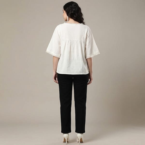 Women-off-white-embroidered-top-with-round-notch-neckline-elbow-length-flared-sleeves-with-fringe-trim-relaxed-fit-and-hip-length-straight-hem
